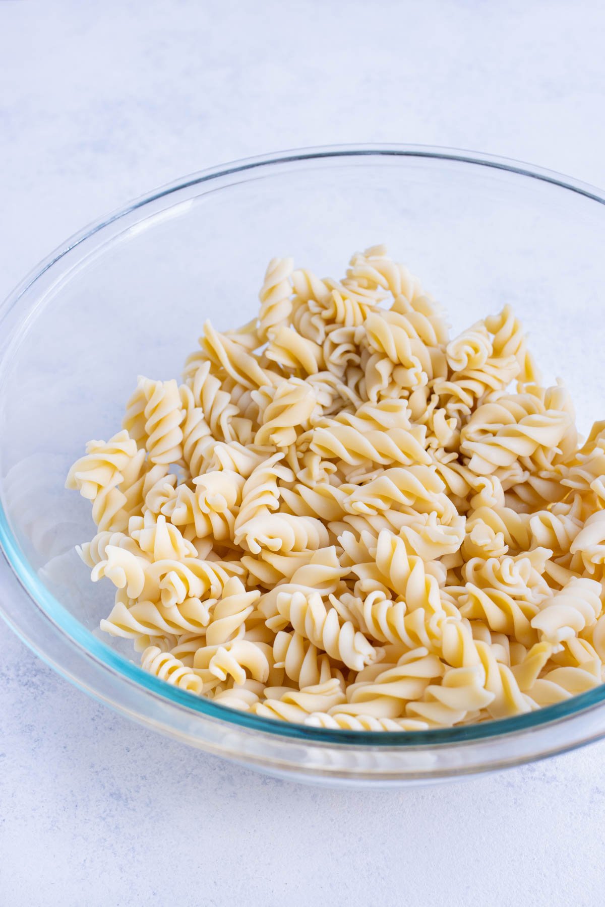 Pasta is cooked, drained, and set in a bowl.