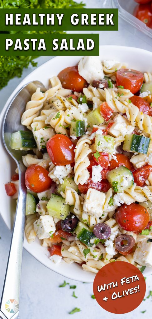 A metal spoon is used to eat cold pasta salad.