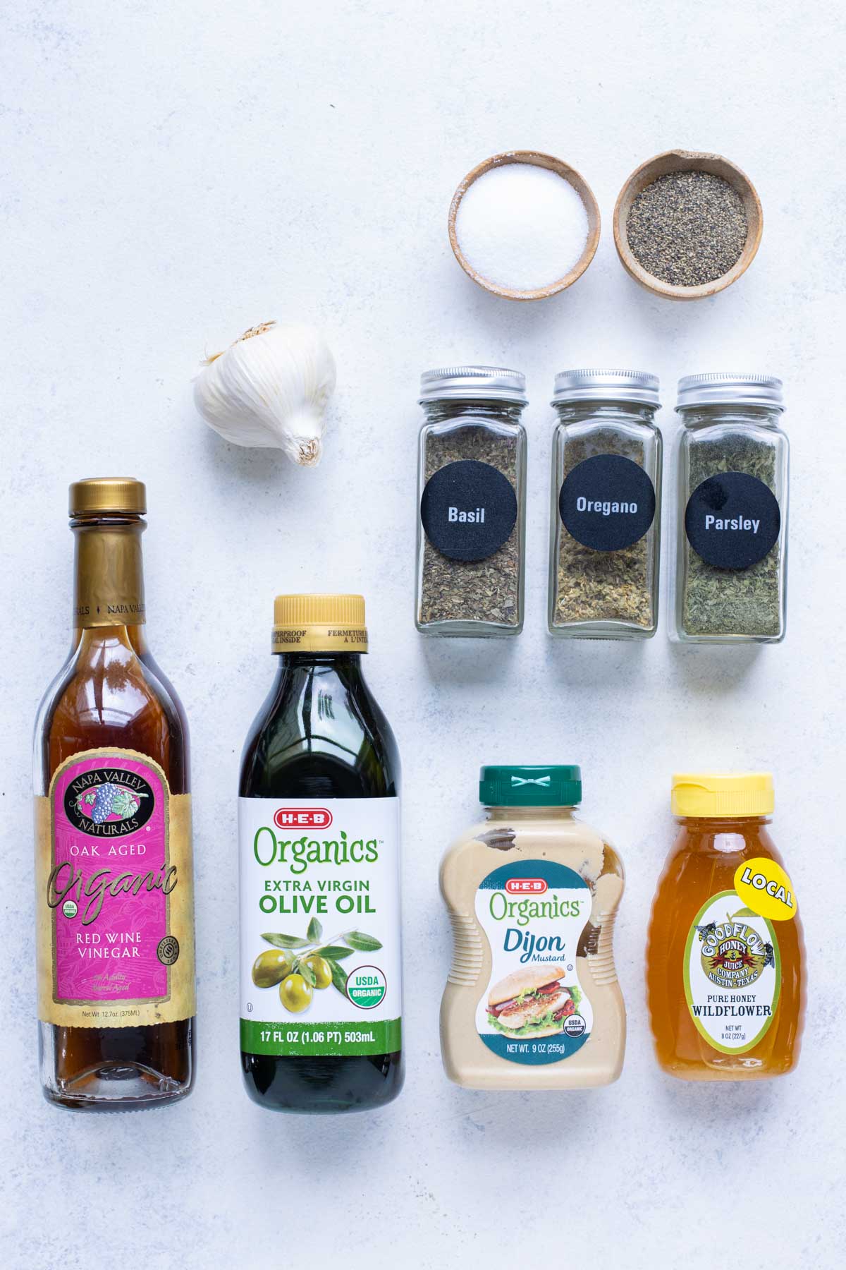 Honey, vinaigrette, olive oil, garlic, dijon mustard, basil, oregano, parsley, salt, and pepper are the dressing ingredients.