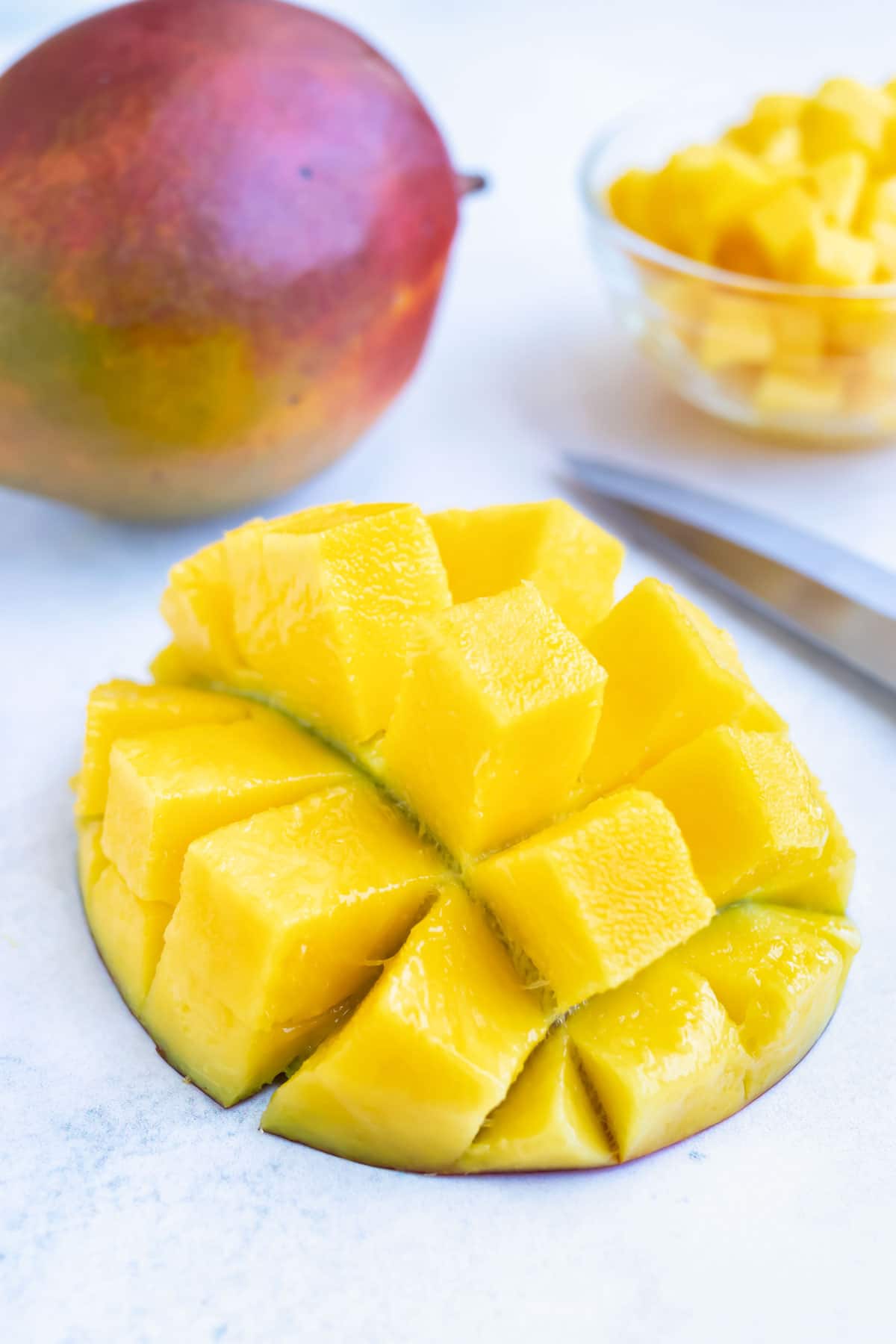 A mango half that has been cut into large chunks.