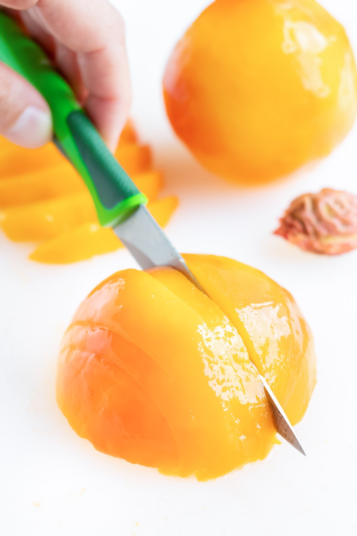 Once the pit is removed, lay one side of the peach down in preparation for slicing.