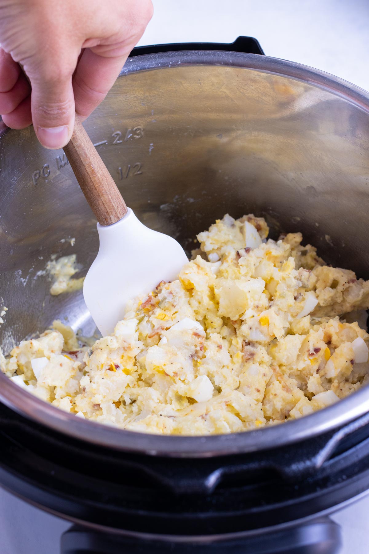 Dressing is added and mixed into the potato salad.