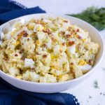 Instant pot potato salad with bacon and eggs is topped with fresh dill.