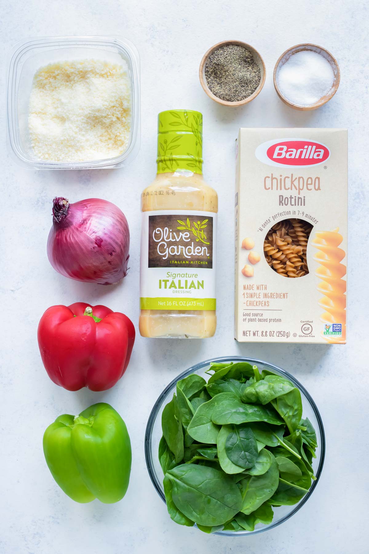 Pasta, onions, peppers, spinach, italian dressing, and Parmesan cheese are the ingredients for this recipe.