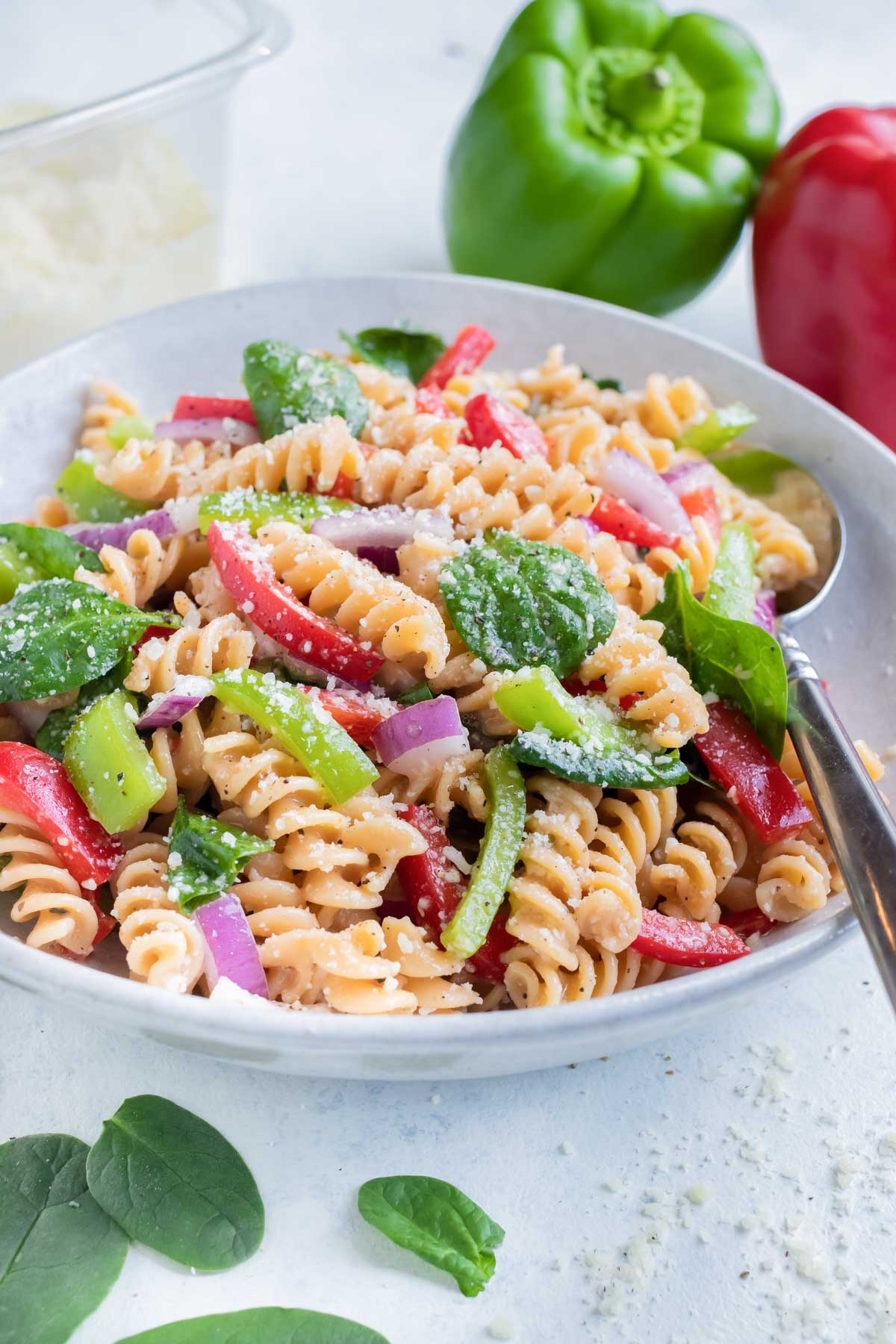 A bowl of Italian Pasta Salad is served with a spoon for a picnic side dish.