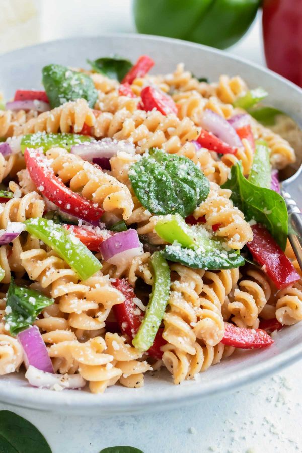 Vegetable Italian Dressing Pasta Salad is served on the counter in a white bowl.