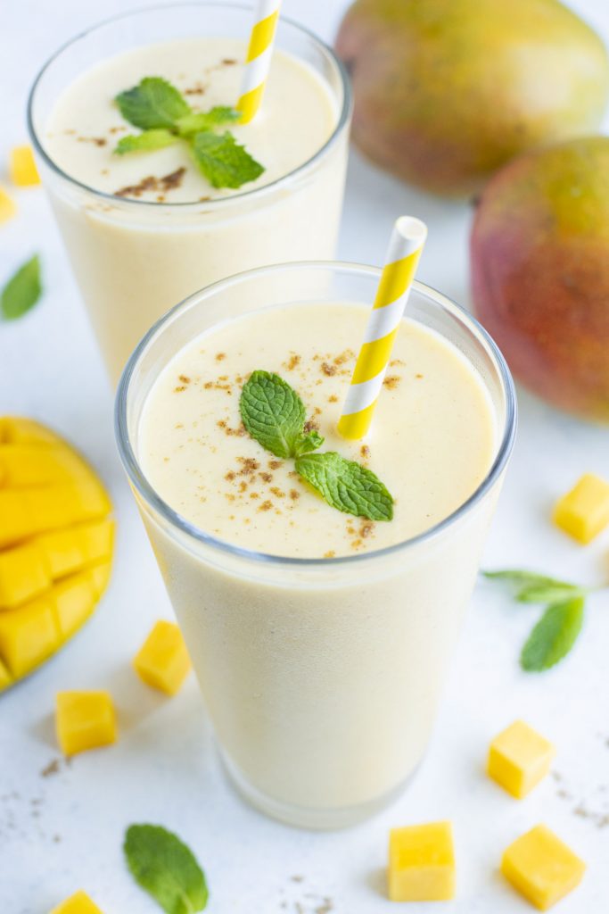 Two glasses of mango lassi are shown on the counter.