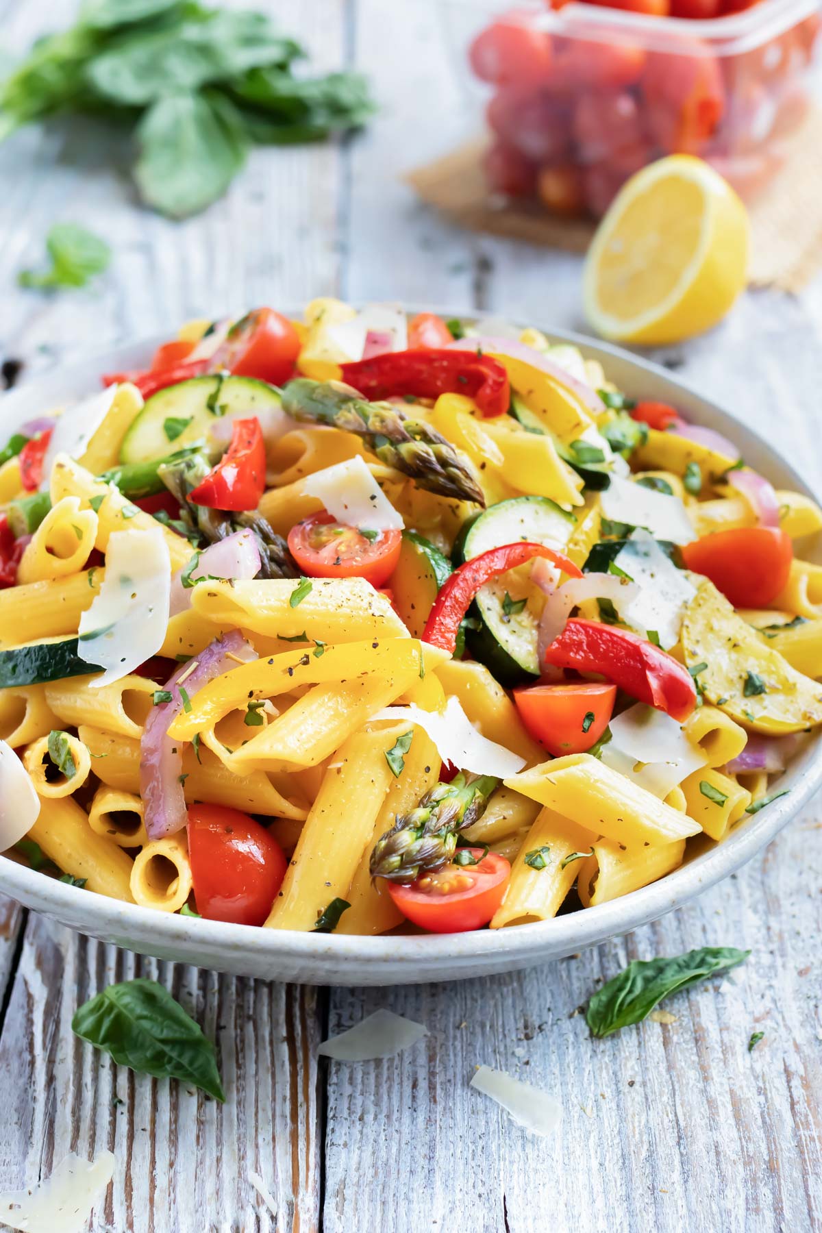 A bowl full of a pasta primavera recipe with lemon butter garlic sauce with basil and tomatoes.