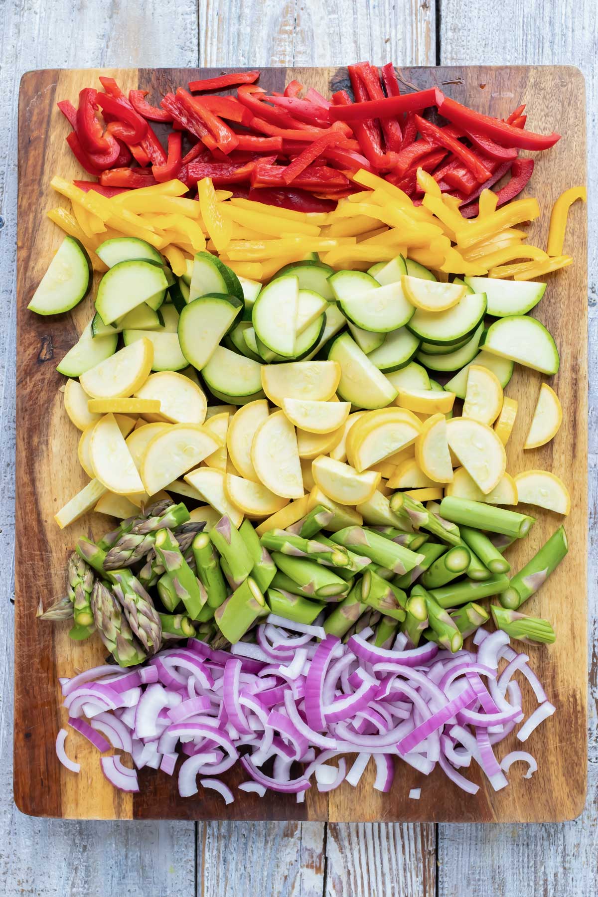 A cutting board full of chopped vegetables.