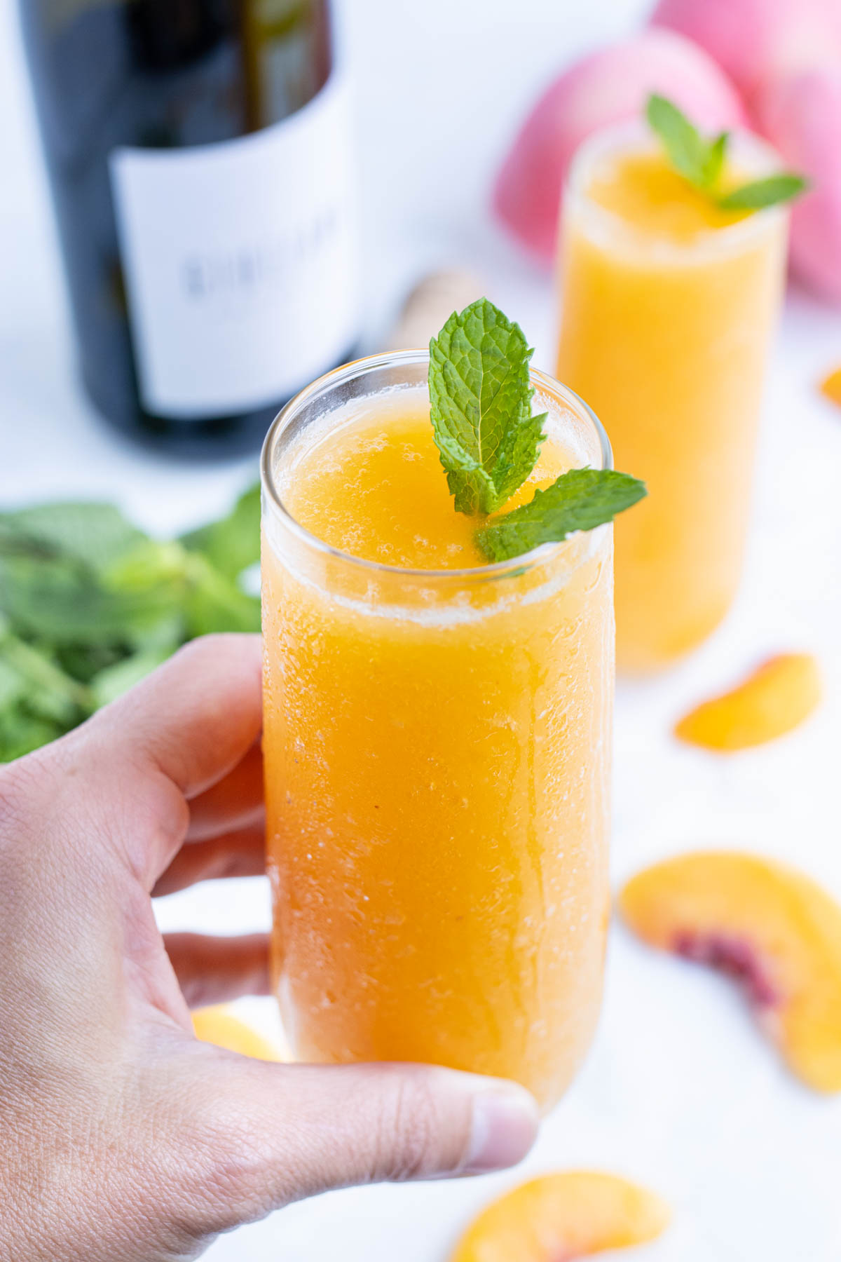 Serve frozen Peach Bellinis in a flute with a sprig of mint