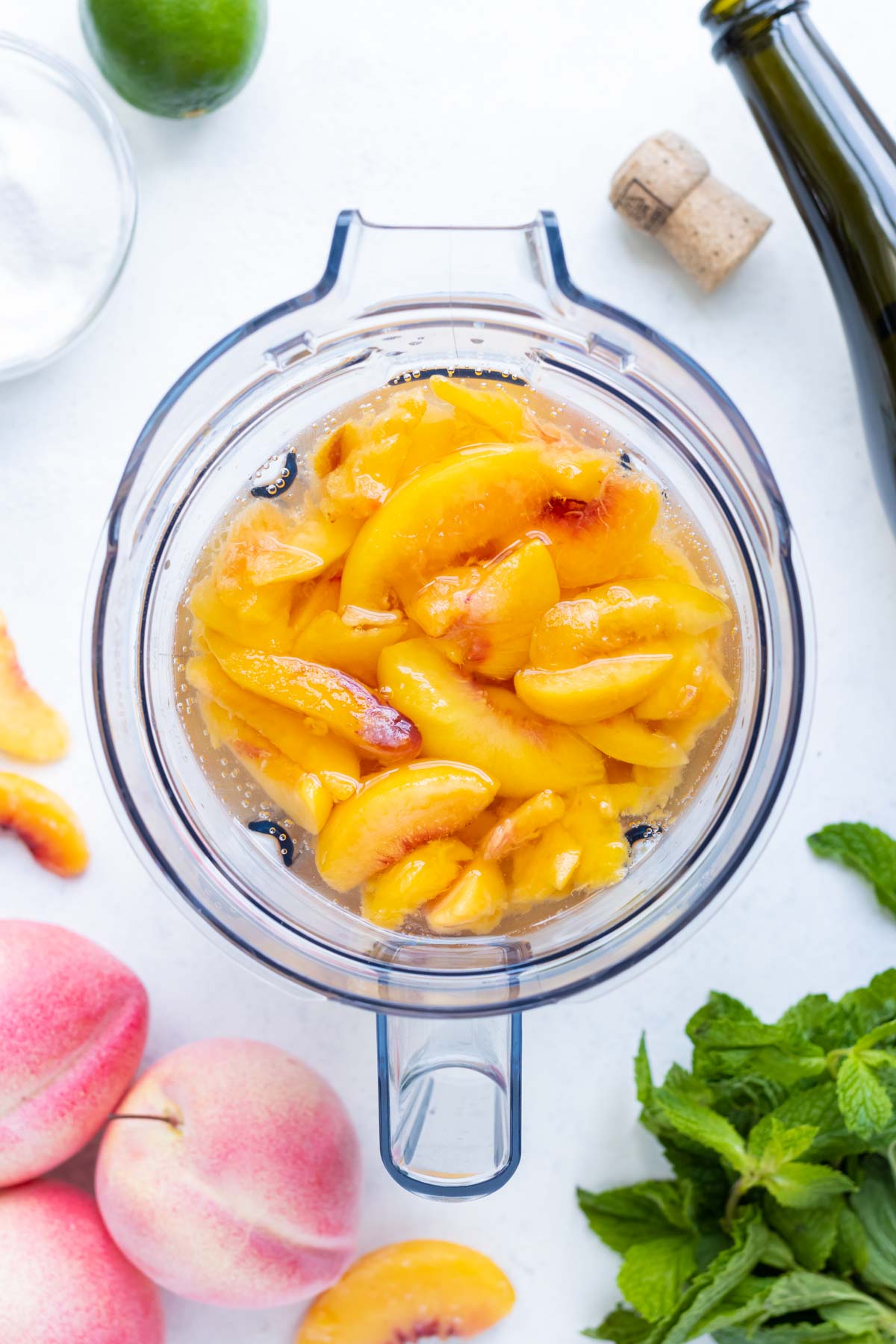 Frozen peaches and prosecco are combined in a food processor.