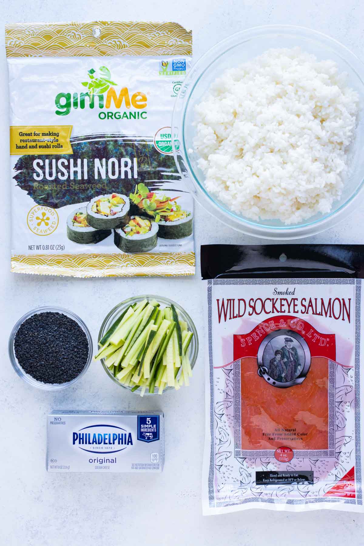 Smoked salmon, rice, nori seaweed, cucumber, cream cheese, sesame seeds are the ingredients for this recipe.