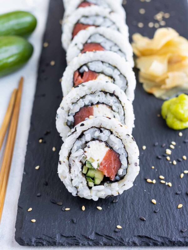 A sushi roll is cut into pieces before serving.