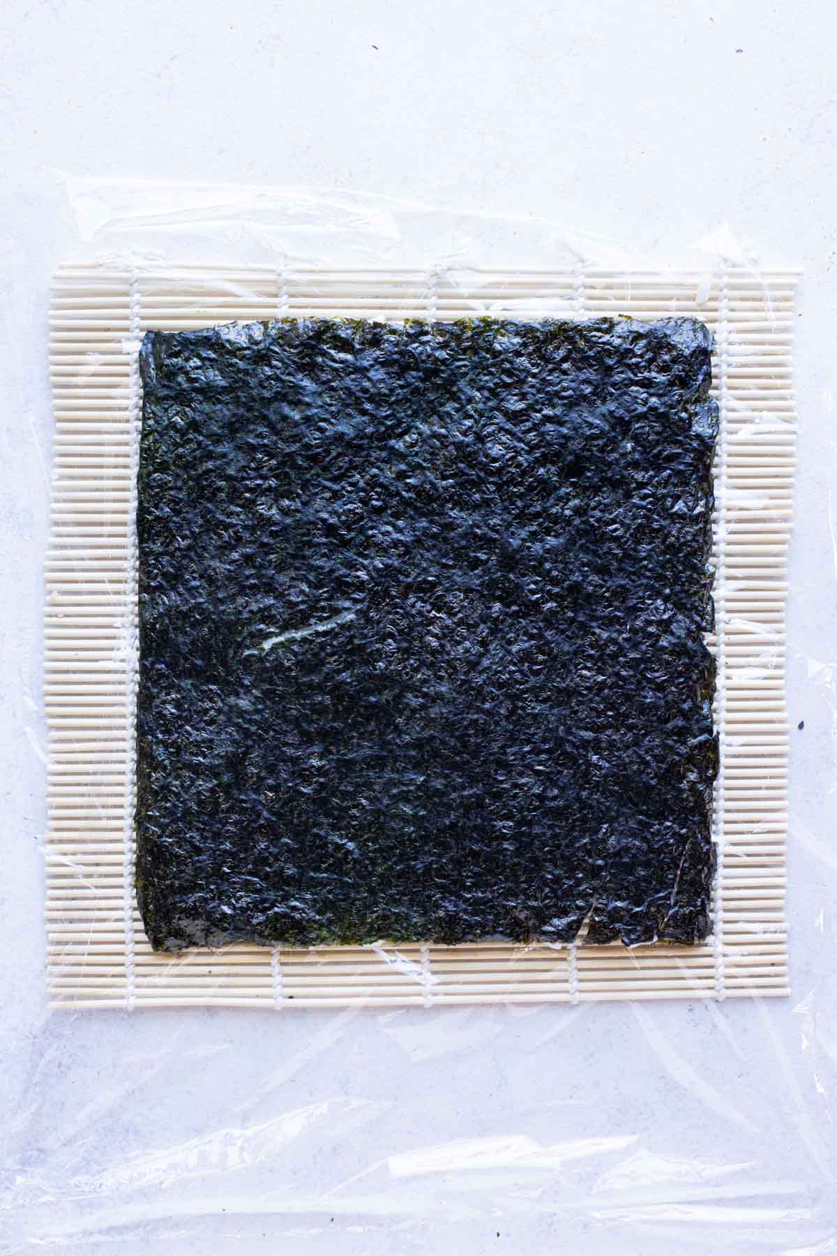 Rice covered nori is flipped over before filling.