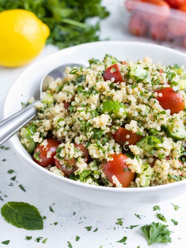 Quinoa salad is shown in a white bowl for a summer recipe.