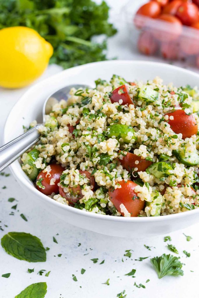 Quinoa salad is shown in a white bowl for a summer recipe.