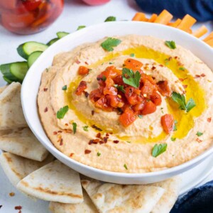 Creamy hummus is served with vegetables and pita.