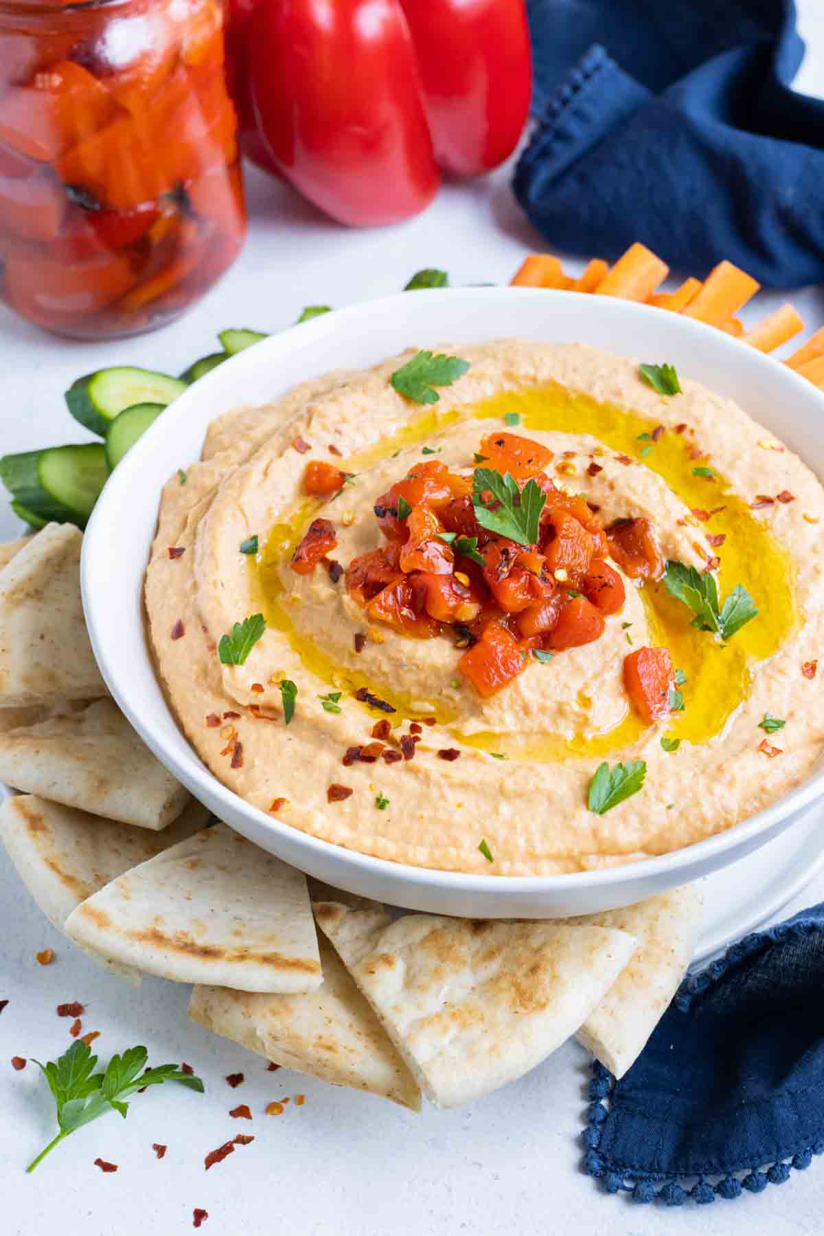 Creamy hummus is served with vegetables and pita.