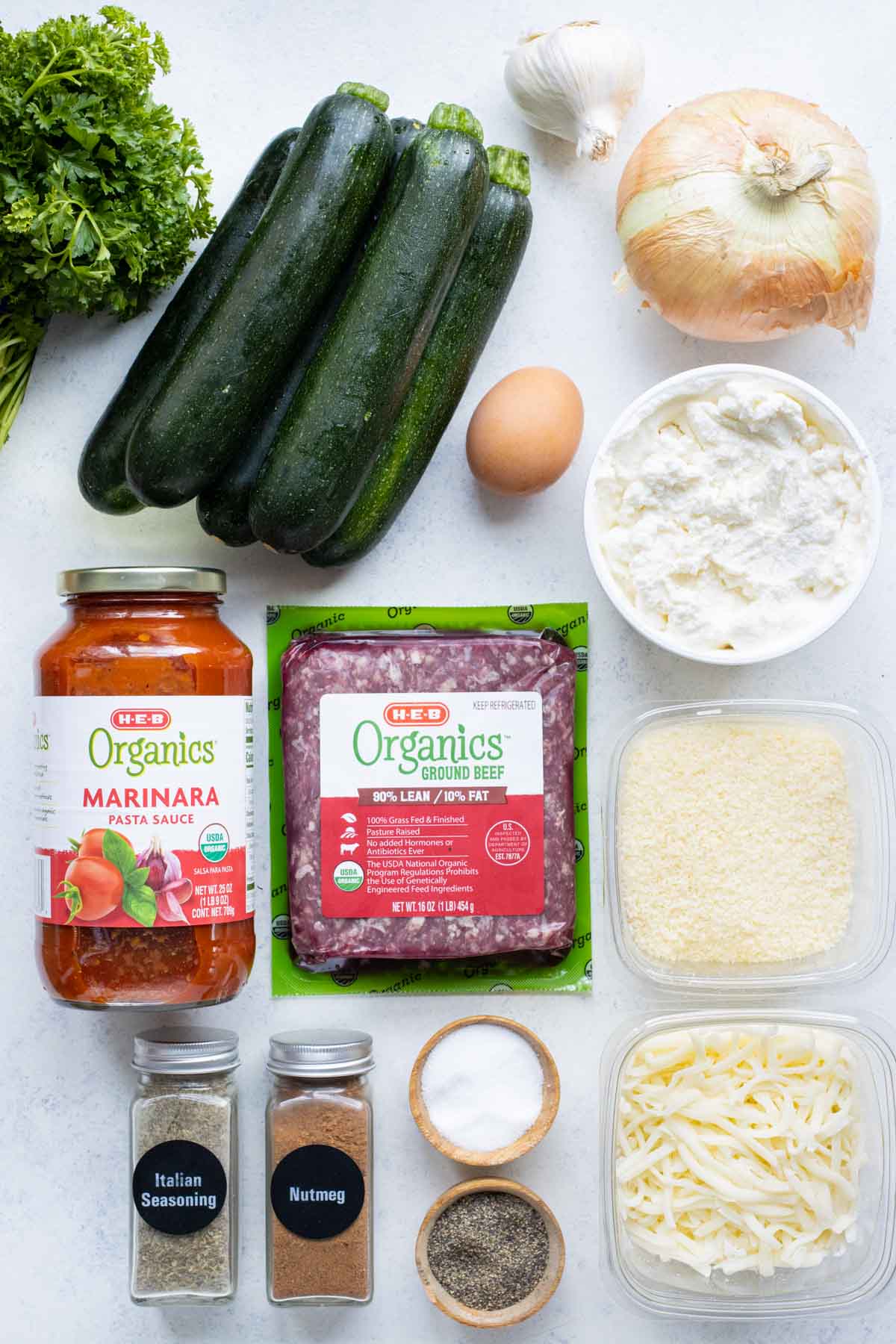 Zucchini, pasta sauce, ground meat, ricotta cheese, and seasoning are the ingredients for zucchini lasagna.