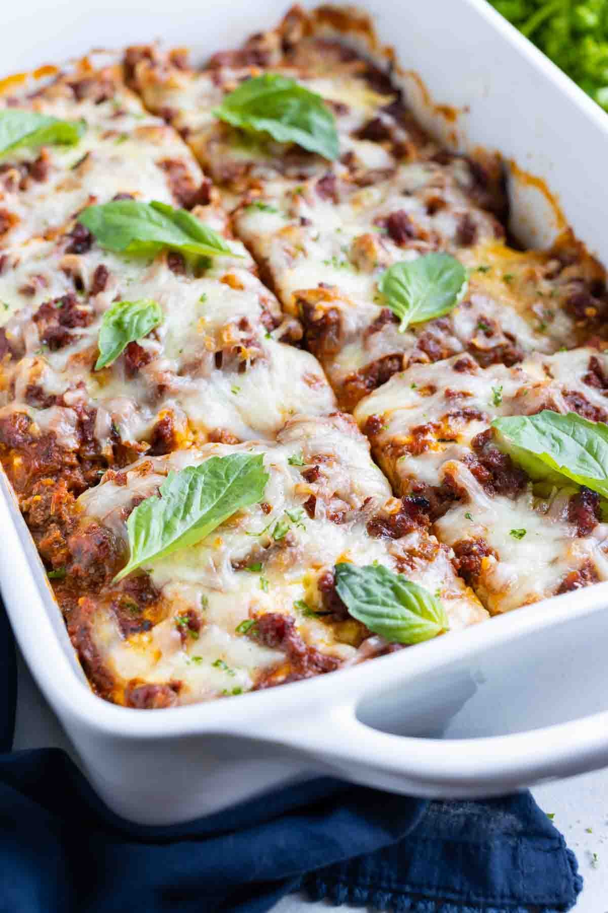 Zucchini lasagna has layers of meat sauce, zucchini, and cheese.