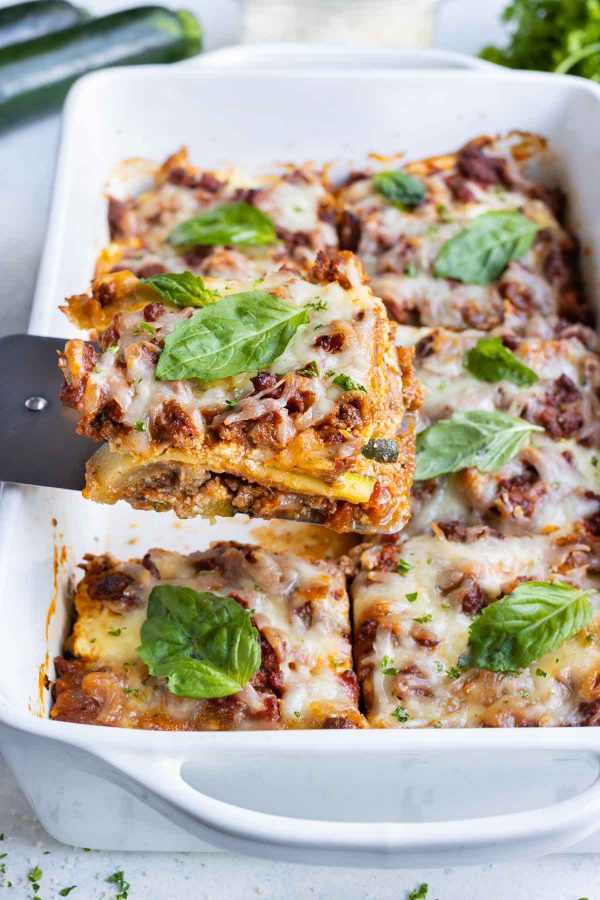 A single serving of zucchini lasagna is scooped out of the dish.