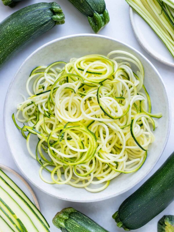 A white plate with spiralized zucchini noodles.