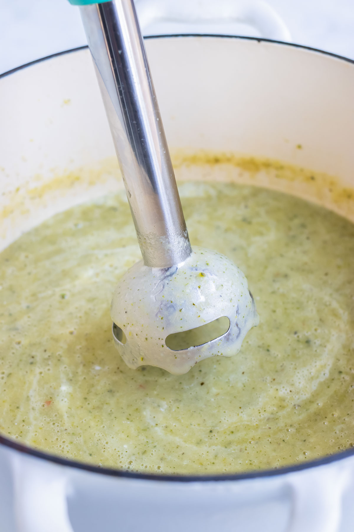 An immersion blender is used to create a smooth soup.