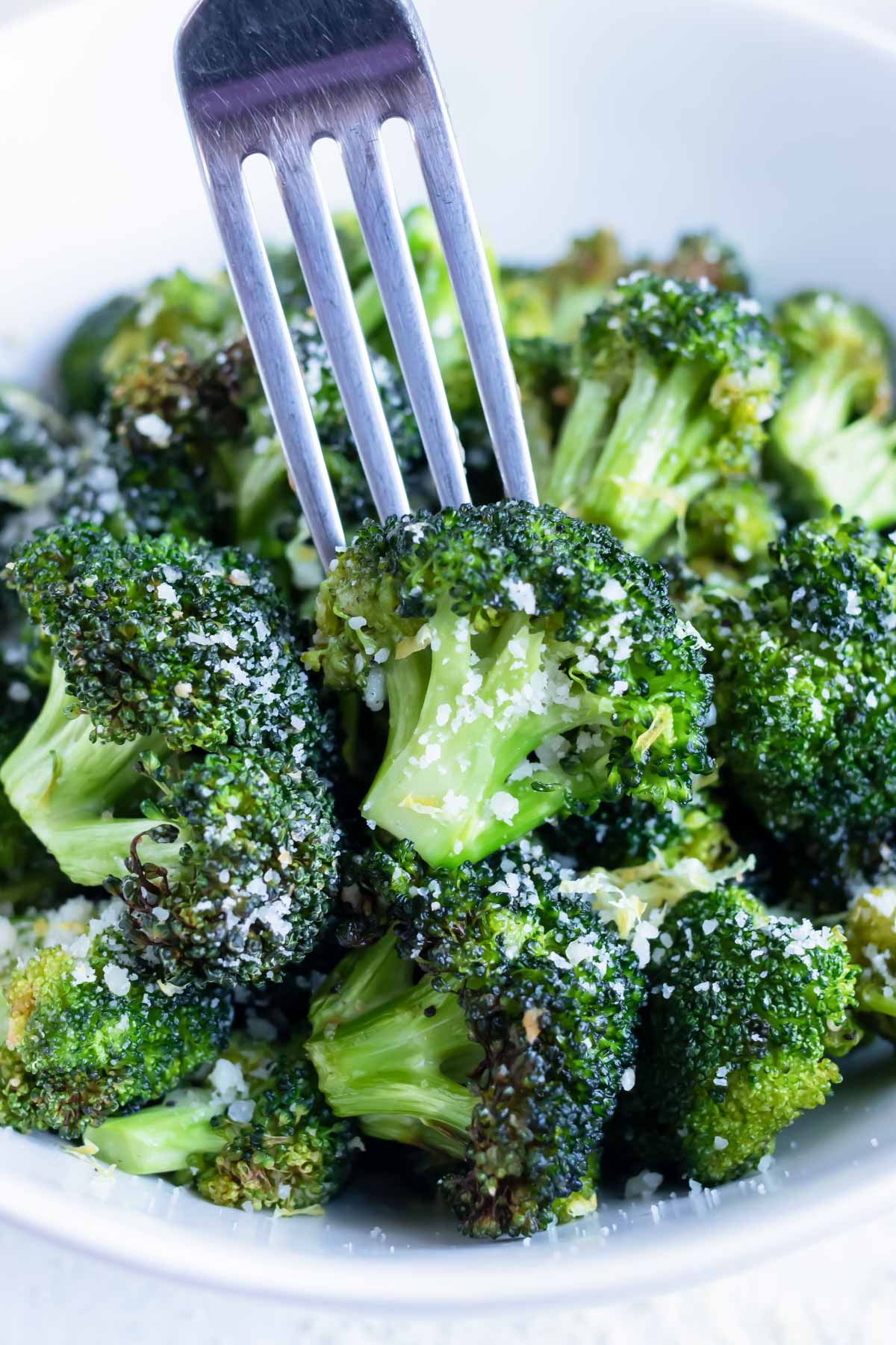 Lemon garlic air fryer broccoli is eaten with a fork.