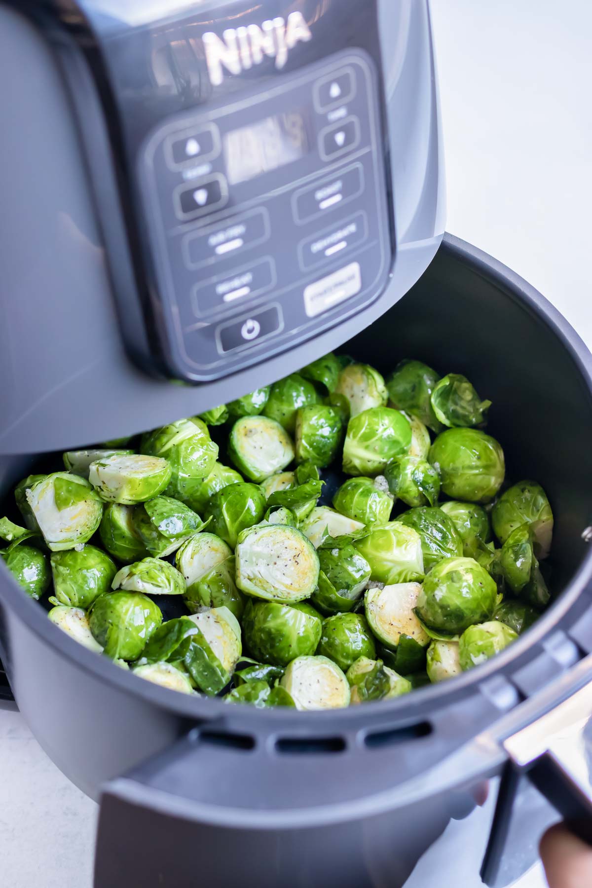 Brussels sprouts are cooked in a Ninja air fryer.