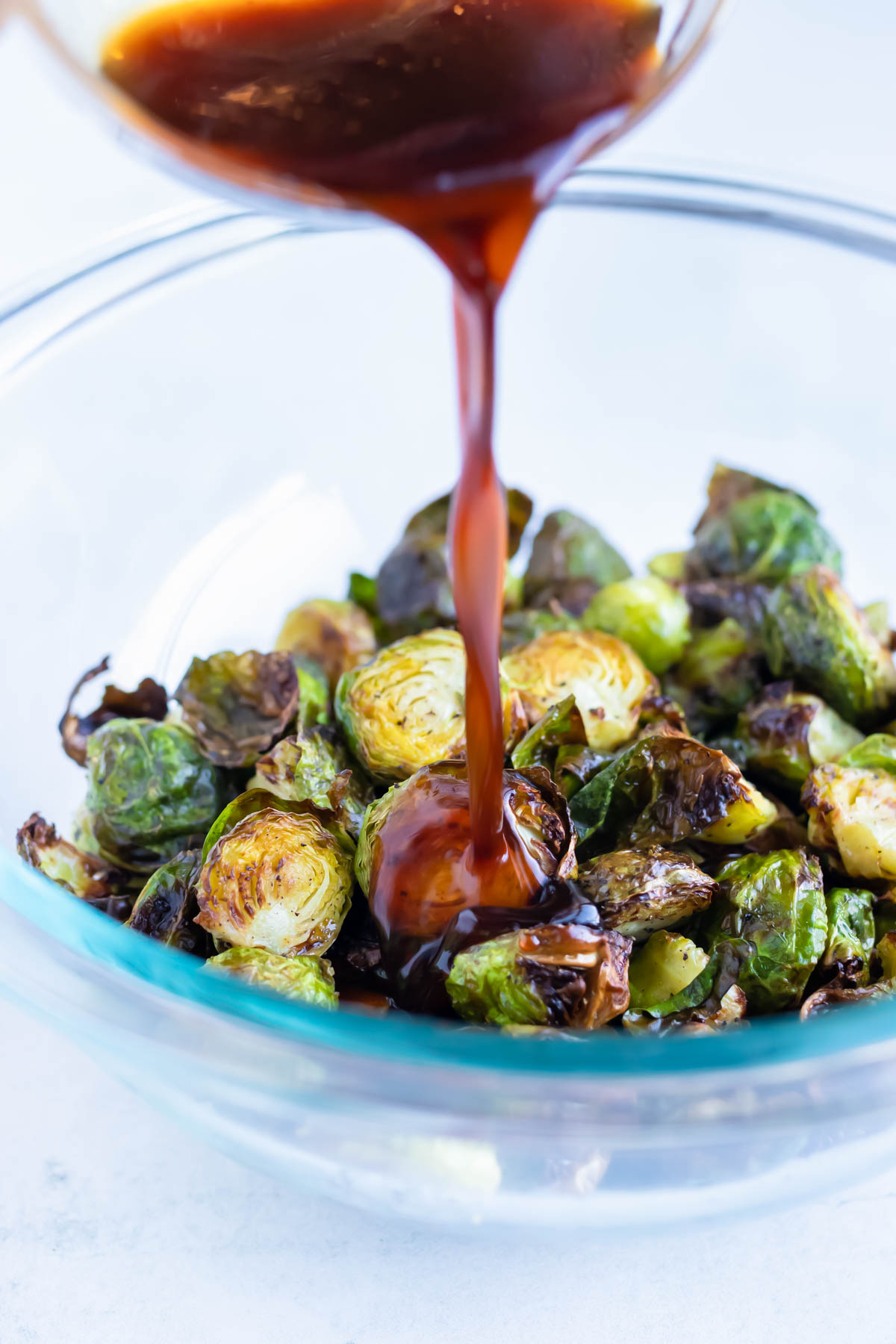 Crispy air fryer brussels sprouts are drizzled with Asian Honey Sriracha sauce.