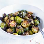 Air fryer Brussel Sprouts are served in a white bowl for a vegan side dish.