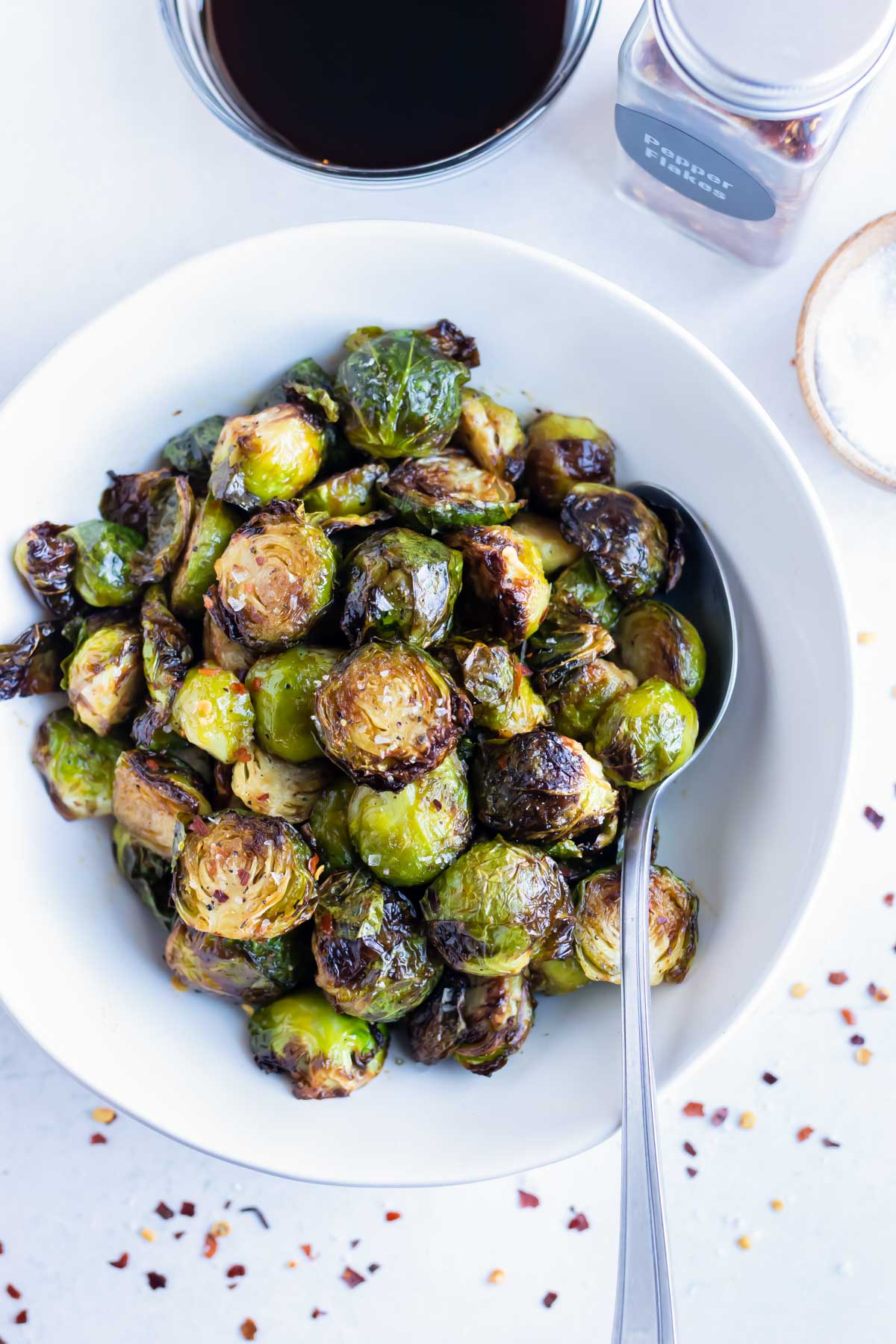 Air fryer brussels sprouts are served in white bowl for a vegetarian dish.