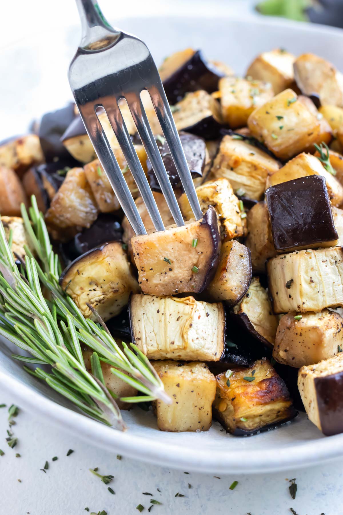 A fork is used to eat the crispy air fryer eggplant.