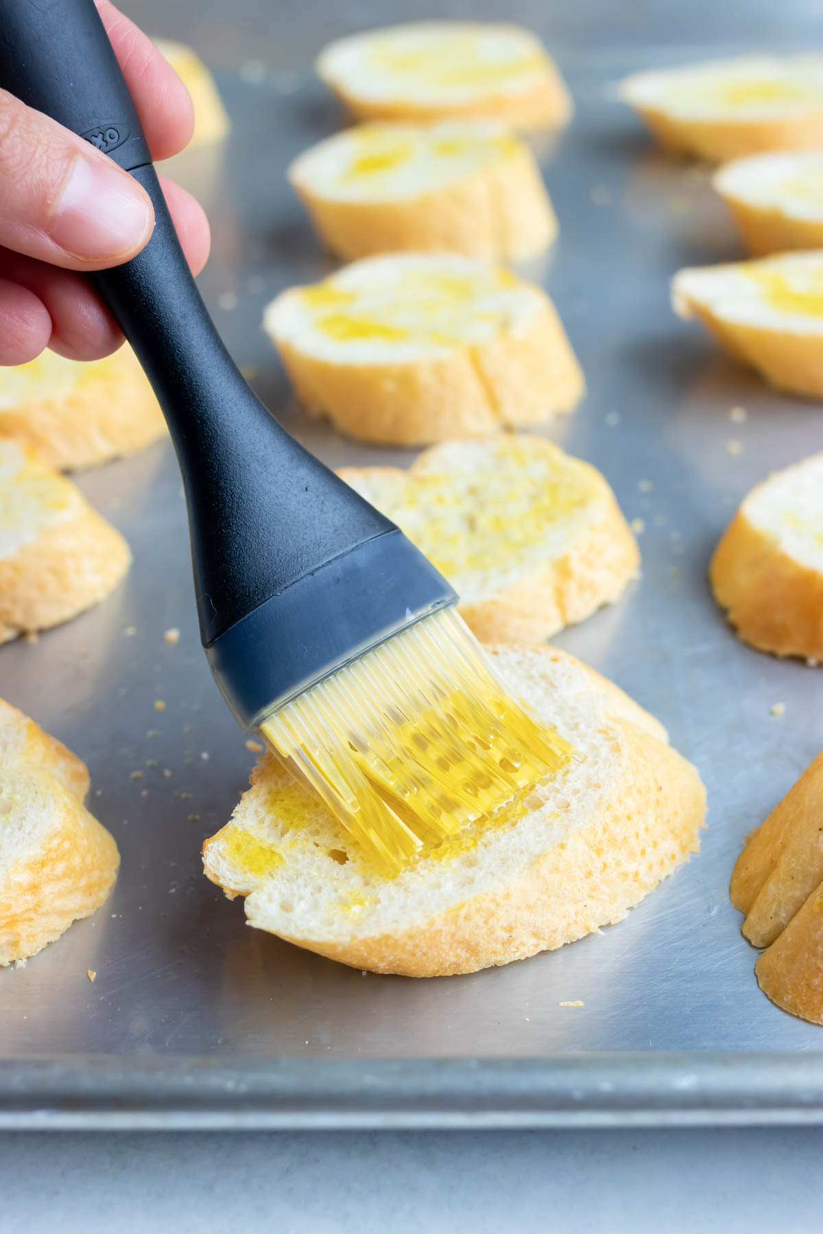 Brushing a piece of bread with oil.