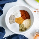 Paprika, garlic powder, onion powder, salt, and black pepper are in a mixing bowl for a homemade burger seasoning recipe.