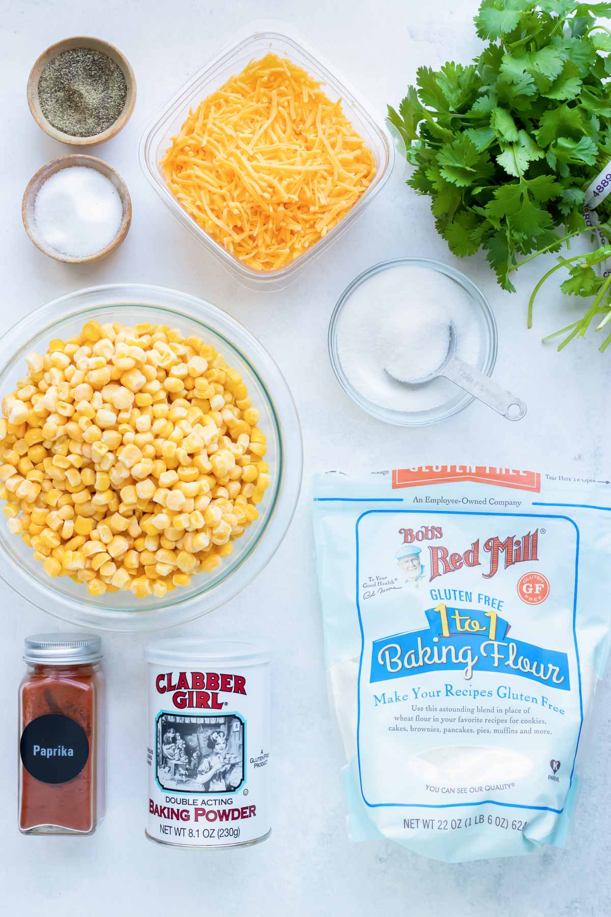 Corn, cheese, flour, cilantro, seasonings, and different types of oil to use for a fried corn fritters recipe.