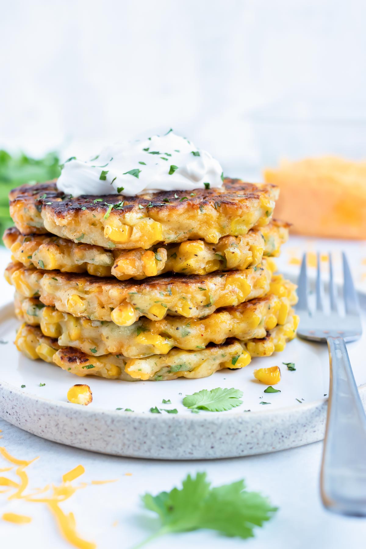 An appetizer plate with easy Southern corn fritters in a stack with fresh cilantro.