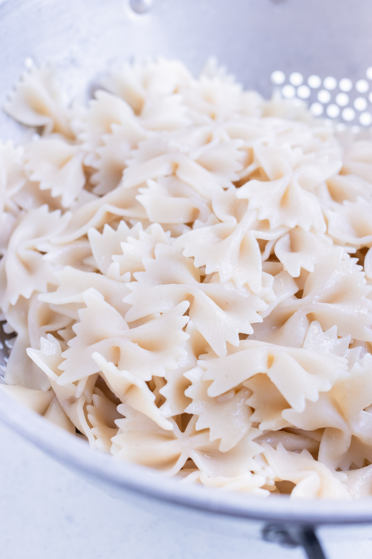 Bowtie pasta is cooked and strained before using.