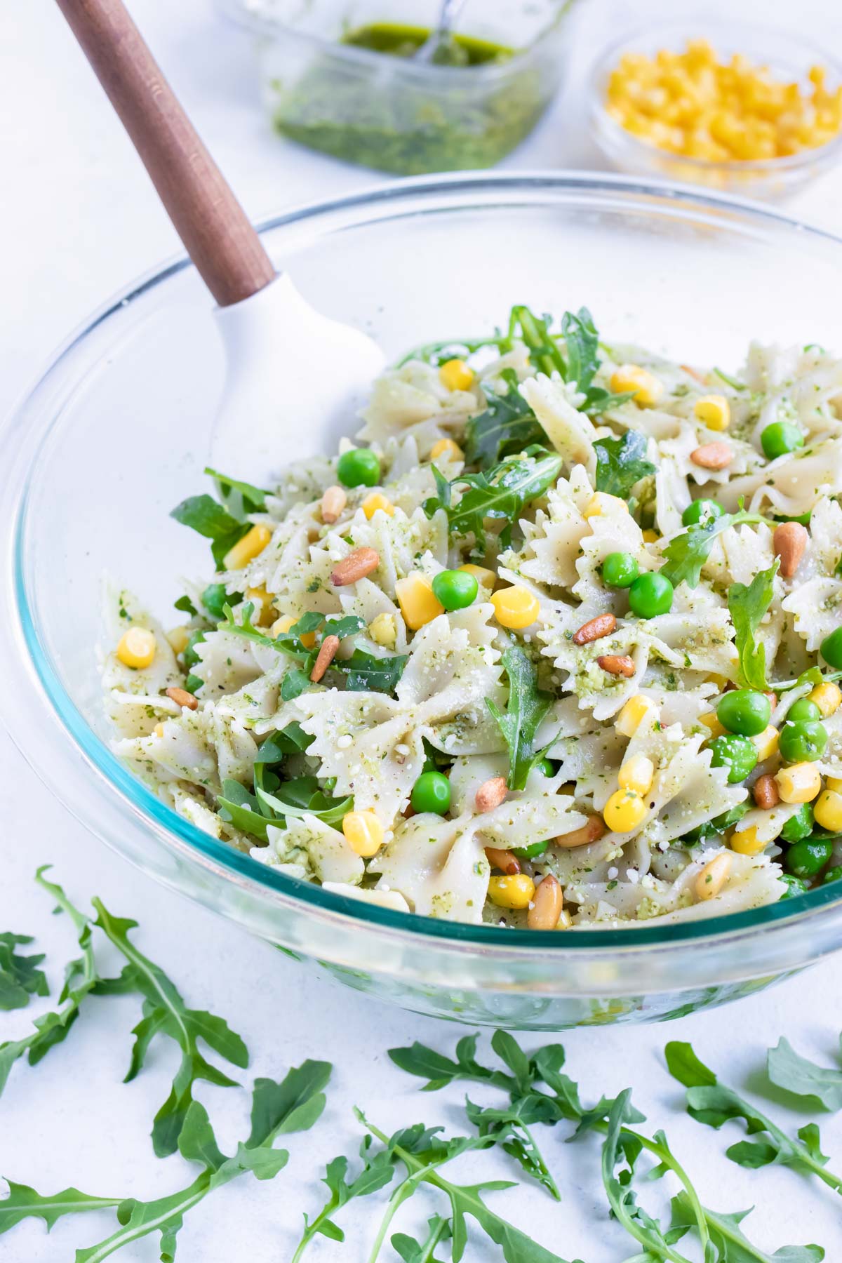 A glass bowl with cold pasta salad is shown on the counter.