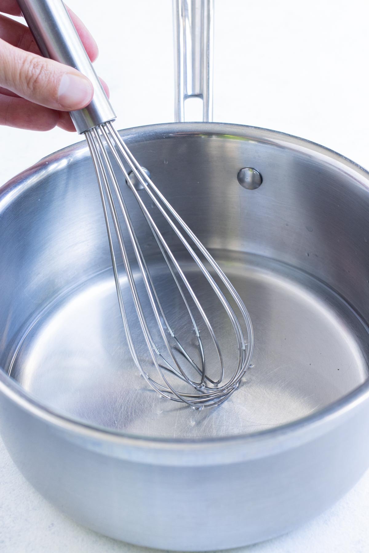 Pickling solution is whisked in a saucepan.