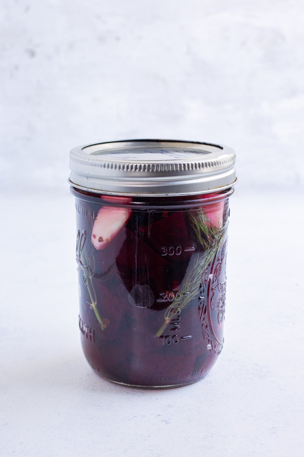 A jar of roasted beets in a brine in a sealed jar.