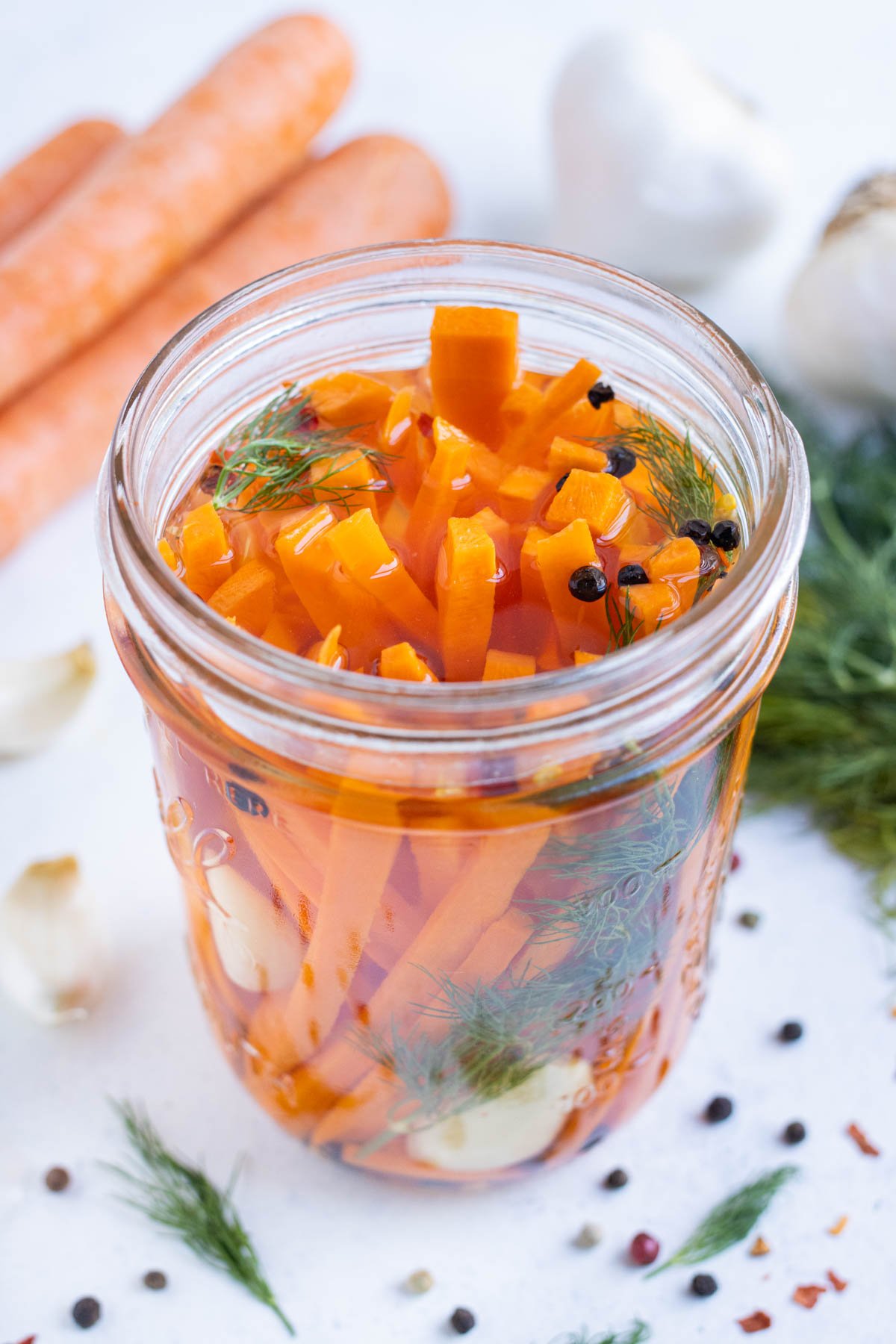 Quick pickled carrots in a brining solution in a jar.