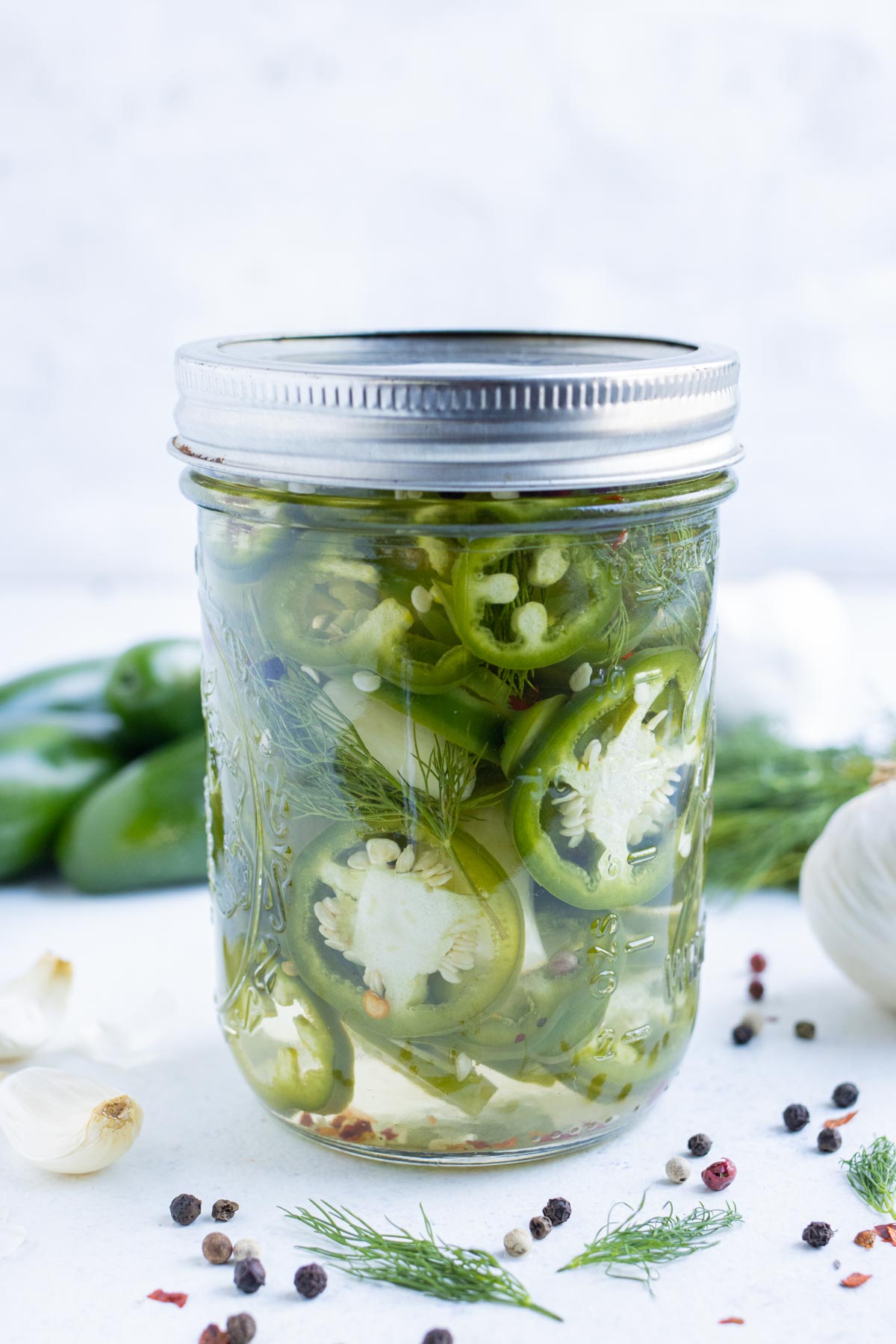 Quick and easy pickled jalapeños in a glass jar.