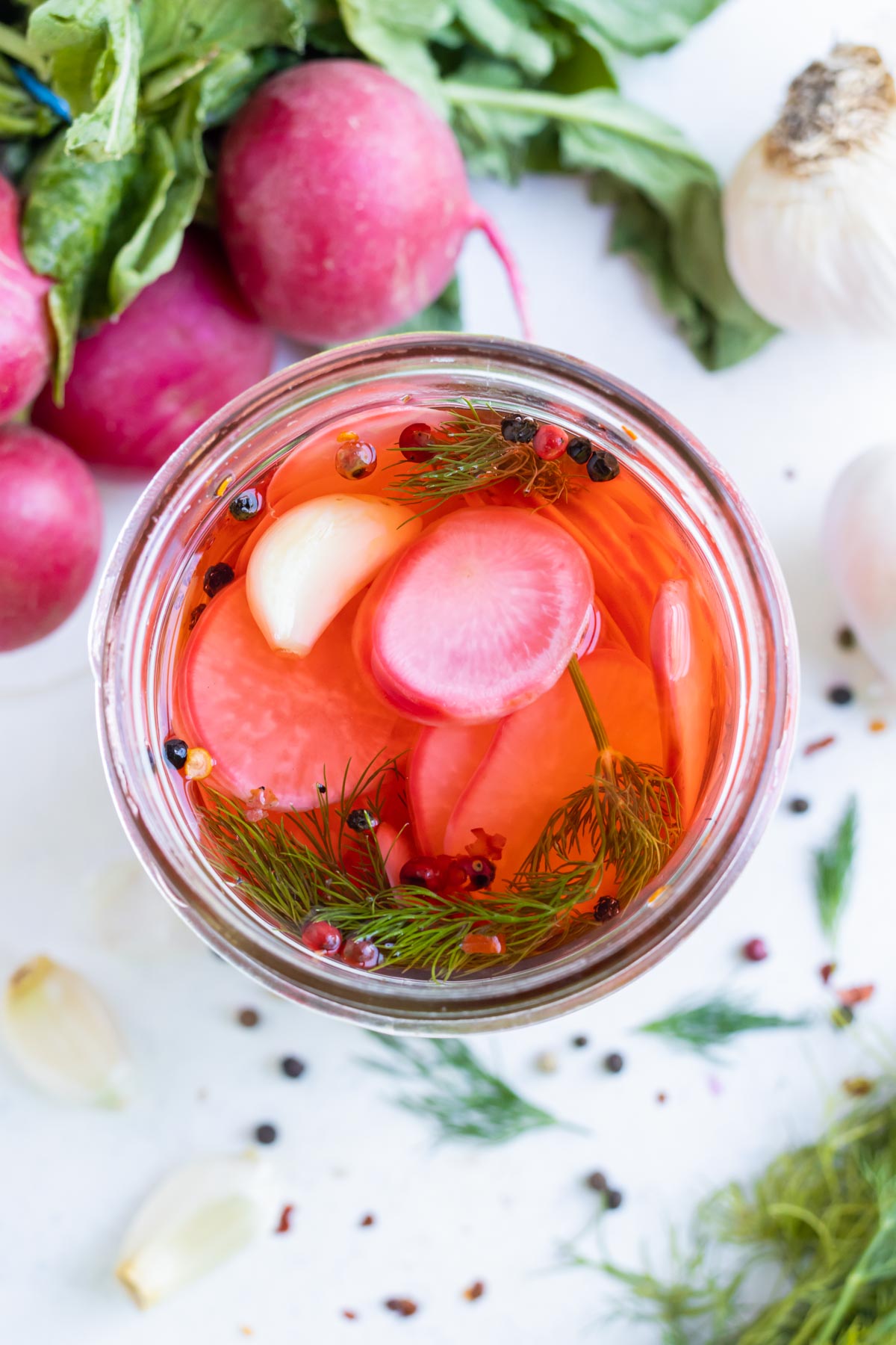 An overhead shot a jar with pickled radishes.