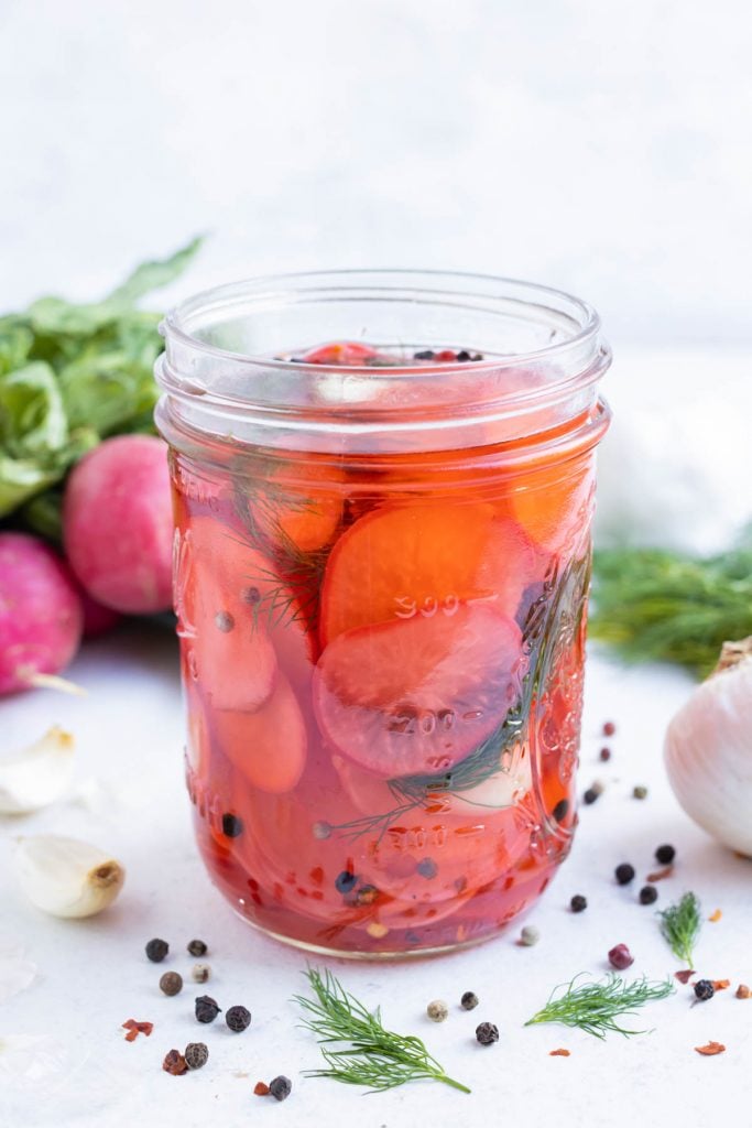 Radishes are pickled in a jar overnight.
