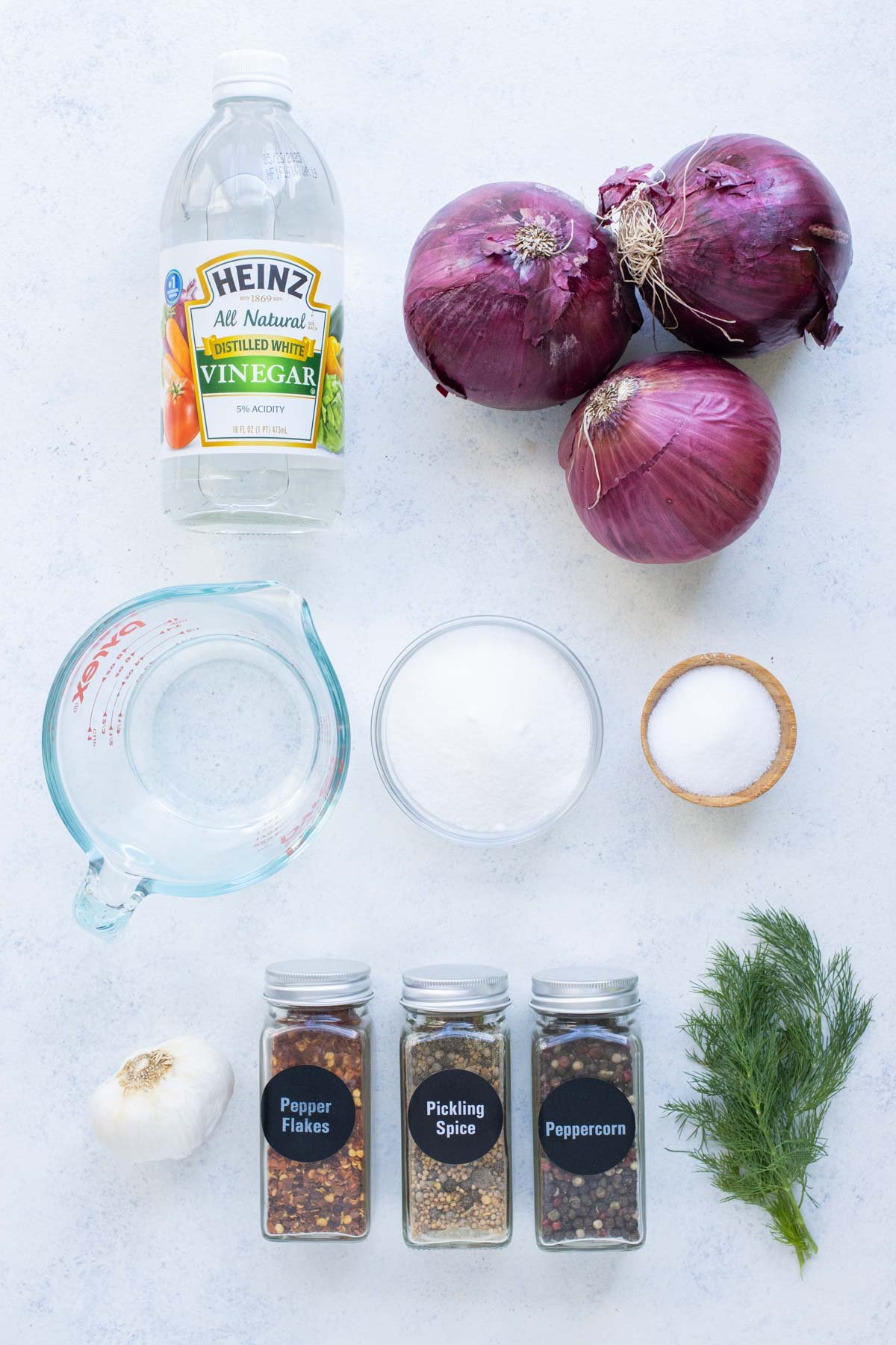 Red onions, vinegar, salt, sugar, and herbs are the ingredients for pickled red onions.