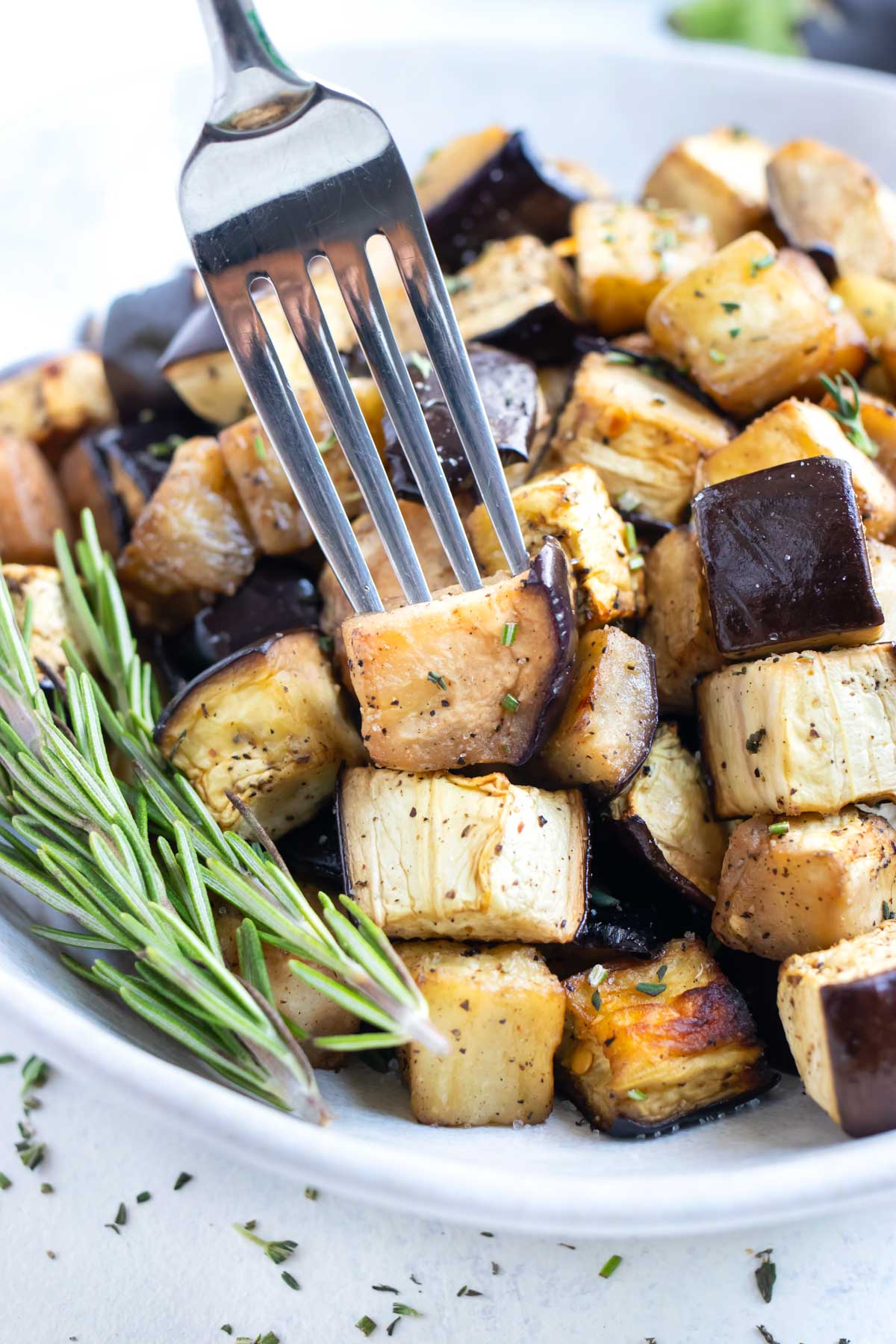 A fork is used to eat the crispy roasted eggplant.