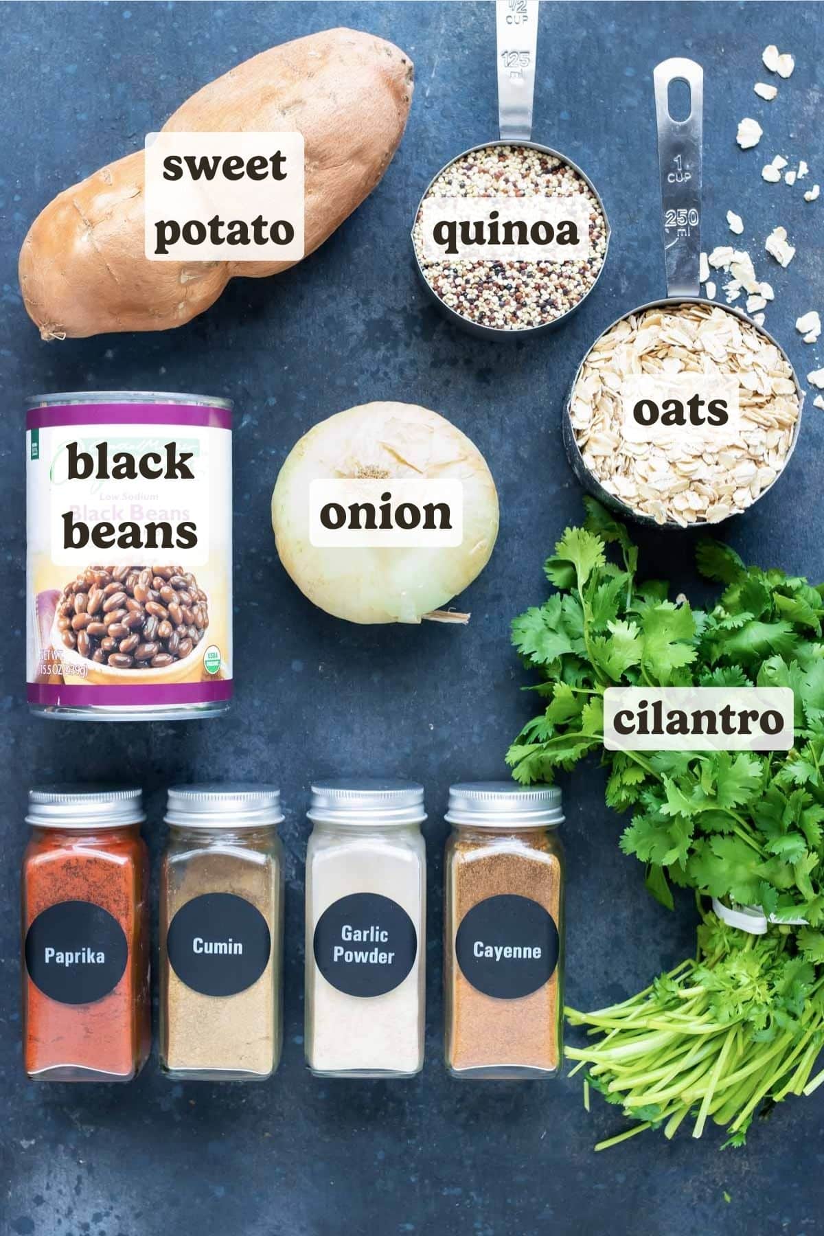 Sweet potatoes, quinoa, oats, spices, and black beans as the ingredients for a vegan burger recipe.