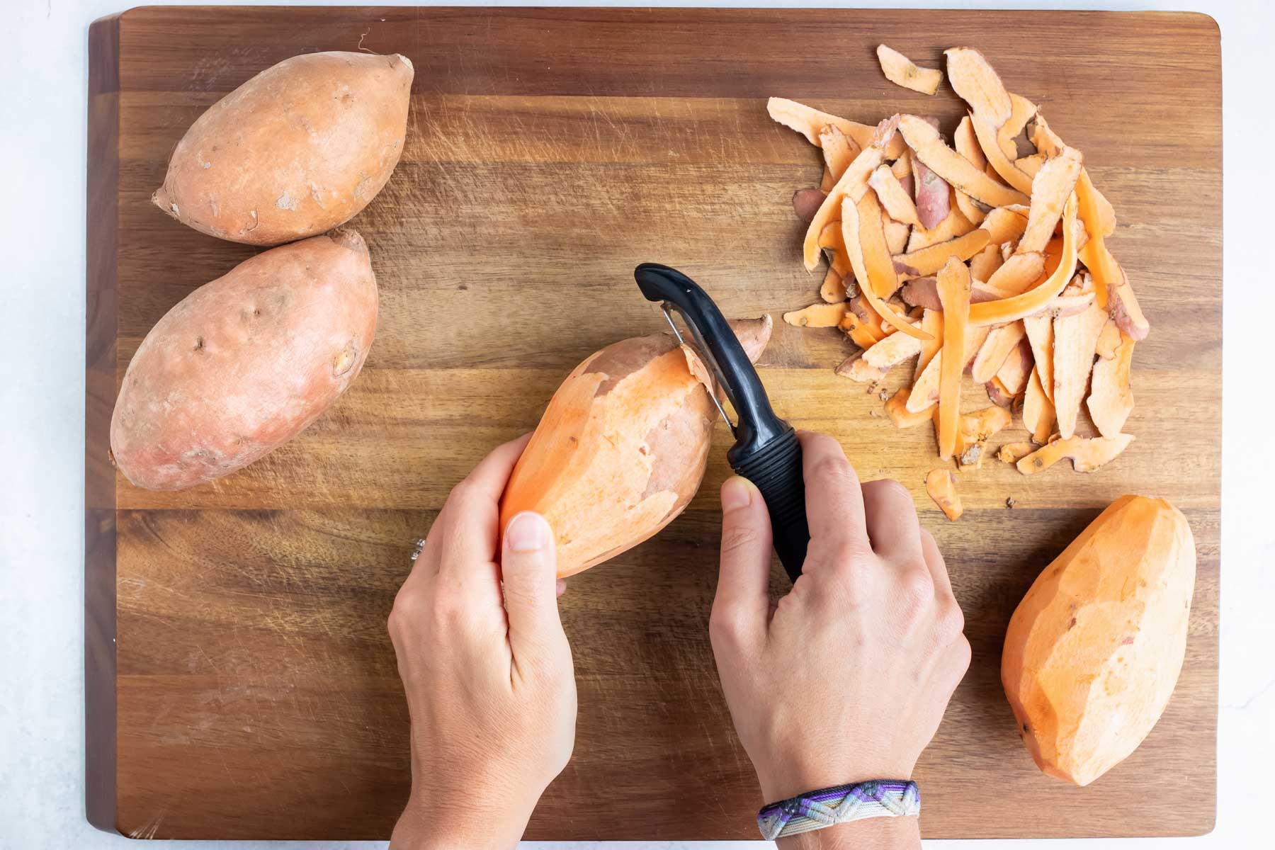 Sweet potatoes are peeled before being sliced.