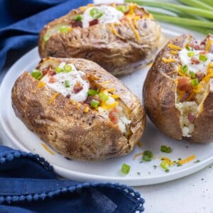 Serve baked potatoes with cheese, chives, and bacon.